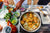 Indian food cooking in a large silver pan.